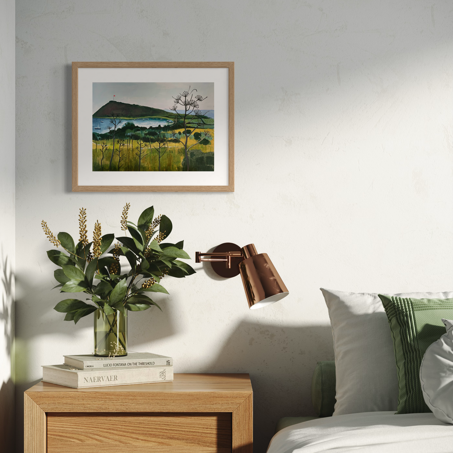 Aegean Autumn landscape by Elaine Boylan. View of Gümüşlük bay on the Bodrum Peninsula in Turkey. Pale blue sky, turquoise sea, hill with flag pole flying the Turkish flag, field in the foreground. Colours are mainly greens, golds and blues. High quality giclée print on fine art paper with mount/mat and classic natural wood frame. Print is shown in a bright, neutral room above a side table beside a sofa.