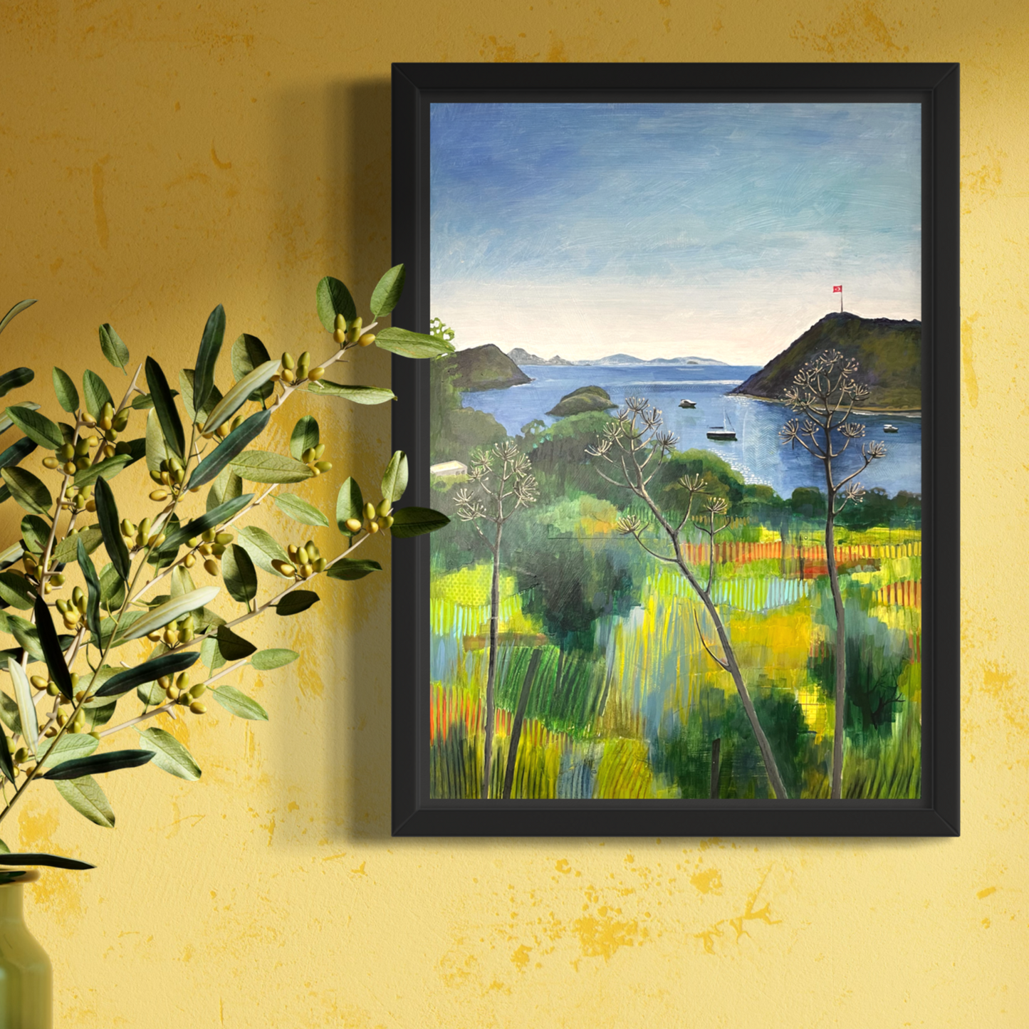 After the Rain mixed media original landscape by Elaine Boylan. View from Gümüşlük on the Bodrum Peninsula in Turkey. Blue sky over the Aegean sea, hill with flag pole flying the Turkish flag, field in the foreground, Greek islands in the distance. Colours are mainly greens, golds and blues. Materials are collage and acrylic paint on board. Framed in a back wood tray frame. Artwork is shown in a bright room on a yellow wall above a sideboard with a vase.