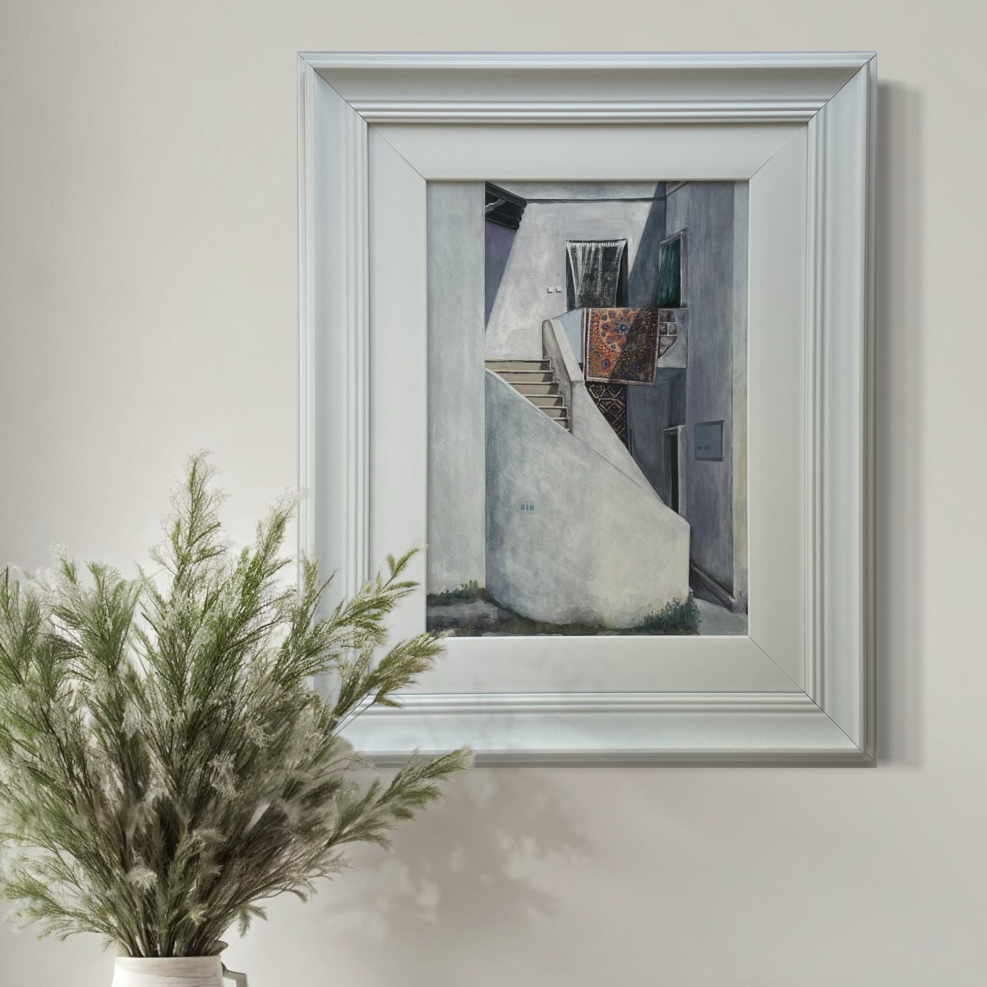 Quiet Backstreet mixed media artwork by Elaine Boylan in a bright room beside a vase of dried grasses.