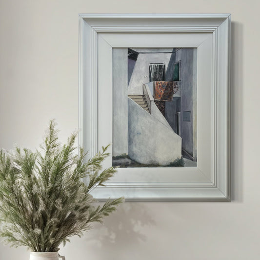 Quiet Backstreet mixed media artwork by Elaine Boylan in a bright room beside a vase of dried grasses.